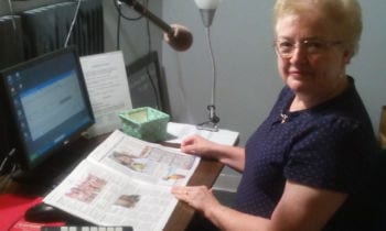 Volunteer Diane Hirtle reads the news live on air.